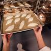 GoPro视角:学生将尖尖的法国面包装入烤箱。